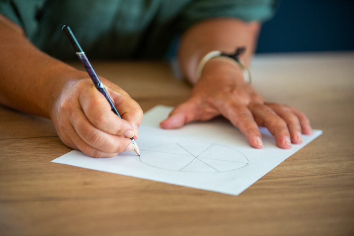 Määränpäävalmentaja Jenni Parkkinen piirtää paperille ympyrän sektoreineen